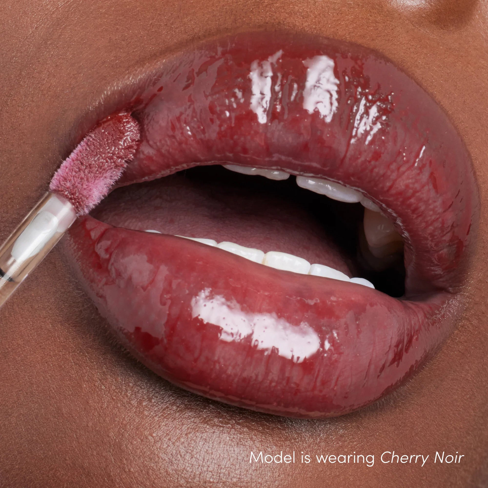 How Colorluxe High Impact Lip Glaze - Shade Cherry Noir look on the lips. Full-bodied, never-sticky lip glaze delivers lustrous color, supreme shine and a cushiony, comfortable feel. Visually volumizes and smooths for a fuller-looking lip. Monecious is a Jane Iredale Australian stockist. Shipping all over Australia.