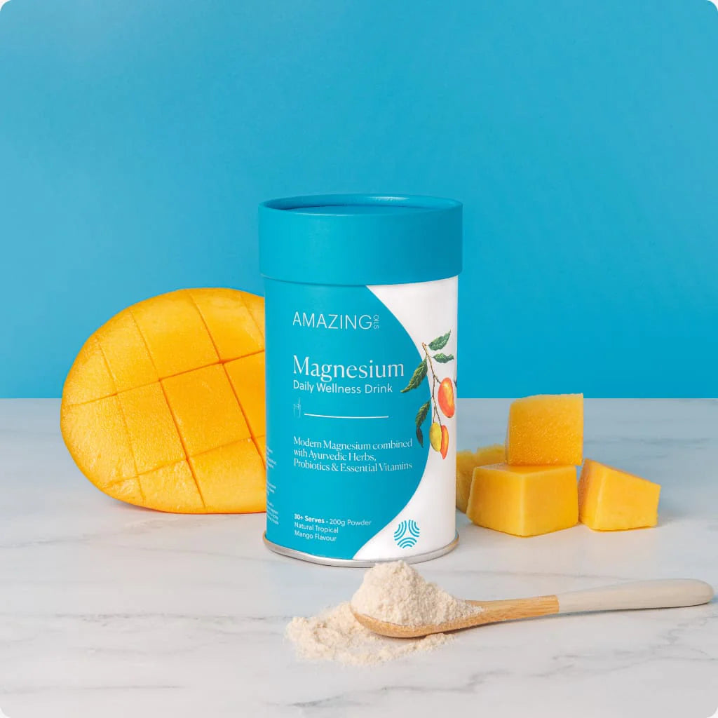 Canister of Amazing Magnesium Daily Wellness Drink with mango pieces on a blue background. Tropical mango wellness drink with magnesium, probiotics, and adaptogens to support digestion, focus, energy, and immune health—naturally. Amazing Oils Australian stockist. Geelong-based. Shop now!