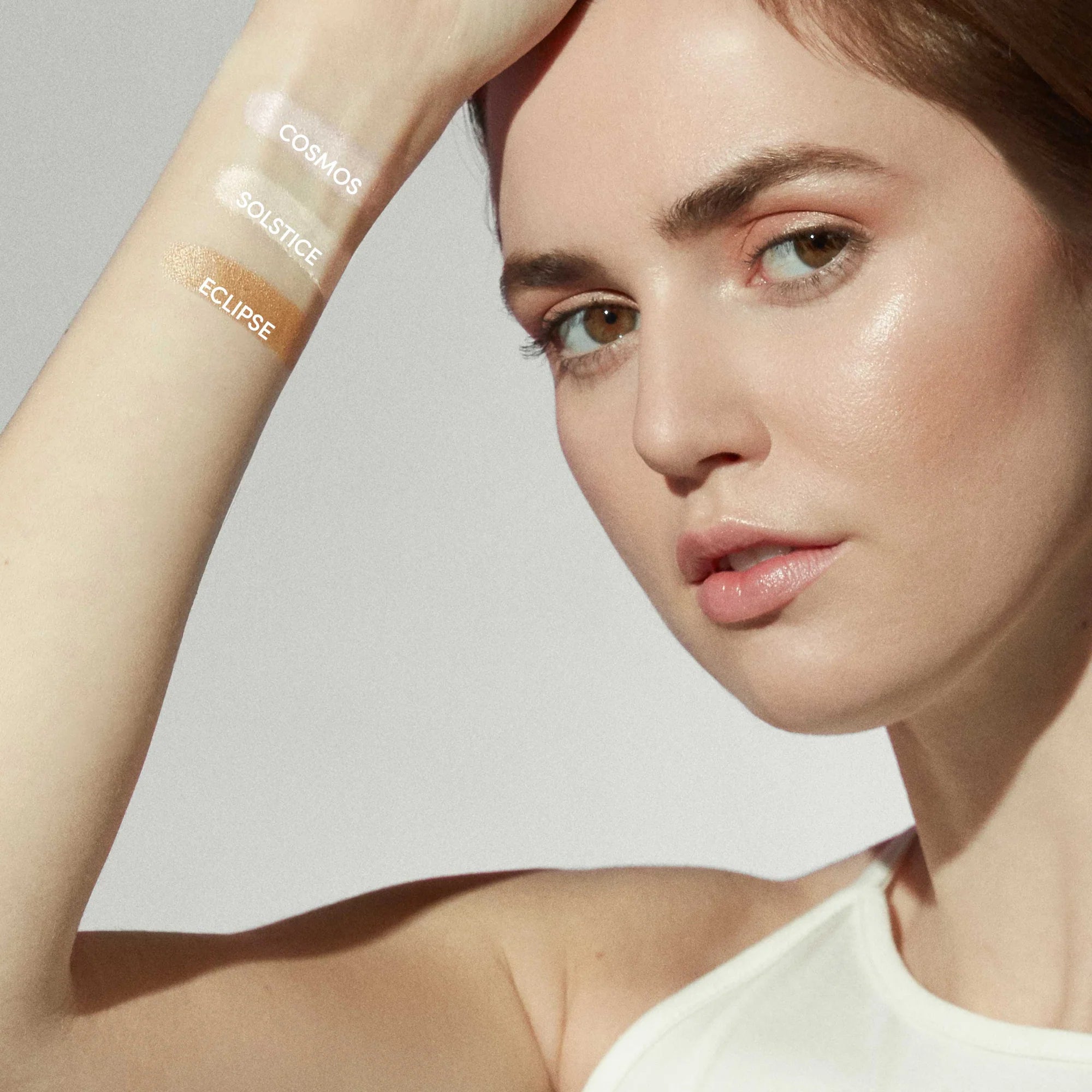 Jane Iredale's Glow Time Highlighter Sticks swatches in the woman's arm.